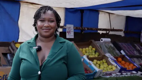 Merya Molnar smiling in front of a market stall.