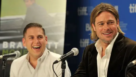 Getty Images Jonah Hill and Brad Pitt speak onstage at &quot;Moneyball&quot; Press Conference during 2011