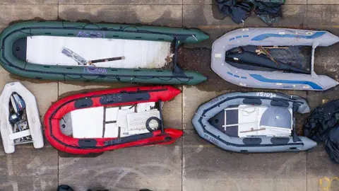 Small boats and outboard motors used by migrants to cross the Channel are seen from above, stored at a Home Office facility, in a photo taken last month